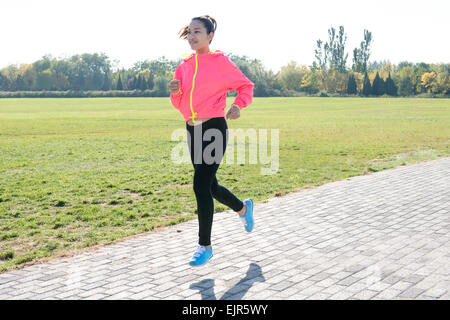 Junge Frau im Park Joggen Stockfoto