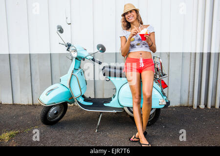 Frau Essen Wassereis in der Nähe von scooter Stockfoto