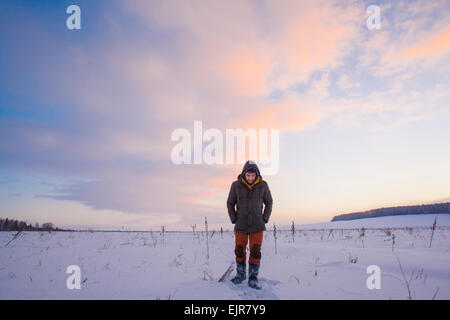 Gemischte Rassen Mann zu Fuß in schneebedecktes Feld Stockfoto