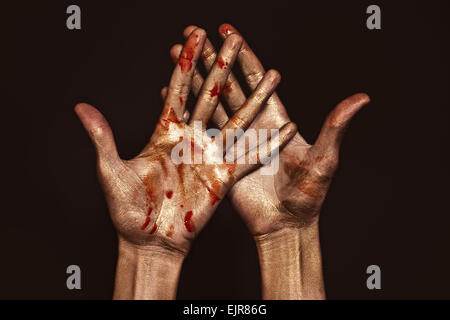 Schöner Mann Hände in goldenen und roten Farbe auf schwarzem Hintergrund hautnah Stockfoto