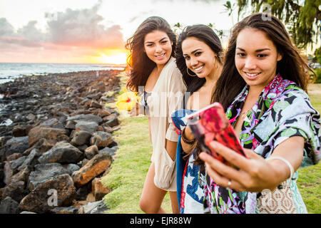 Pacific Islander Frauen Handy Fotografieren in der Nähe von felsigen Strand