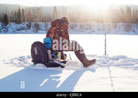 Mari Mann Eisfischen in schneebedecktes Feld Stockfoto