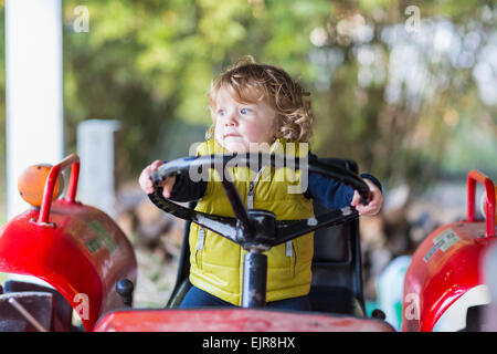 Kaukasische Baby Boy treibende Traktor Stockfoto