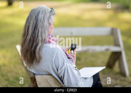 Ältere Frau kaukasischen mit Handy im freien Stockfoto