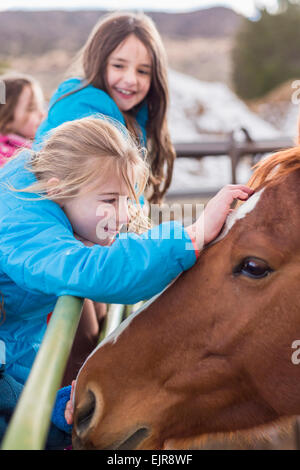 Kaukasische Mädchen streicheln Pferd auf der ranch Stockfoto