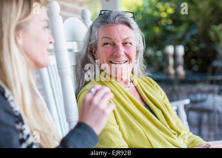 Kaukasische Mutter und Tochter sprechen auf Veranda Stockfoto