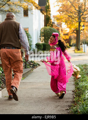 Afroamerikanische Mädchen treating mit Vater auf Halloween Stockfoto
