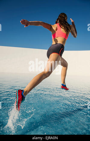 Kaukasische Frau läuft auf Wasseroberfläche Stockfoto