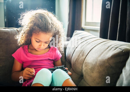 Gemischte Rassen Mädchen mit digital-Tablette auf sofa Stockfoto