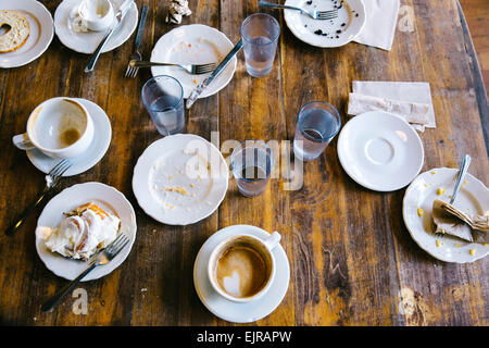 Leere Teller, Tassen und Gläser am Café-Tisch Stockfoto