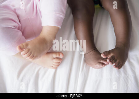Nahaufnahme der Beine des Babys auf Bett Stockfoto