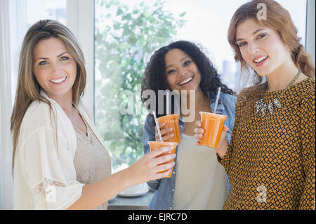 Frauen, die gesunde Saft zu trinken, in der Nähe von Fenster Stockfoto