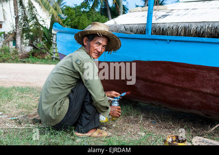 Fischerdorf - Lifestyle - Kep, Kambodscha, Asien. Ein Mann, der sein Boot Malerei. Stockfoto