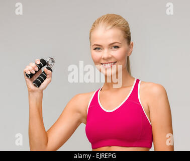 lächelnde Frau mit Hand expander Stockfoto