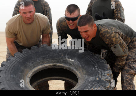 Ein Team von fünf Soldaten zugewiesen, die 1. Brigade Combat Team, 1. Kavallerie-Division, Flip ein Reifens während der harten Mudder Centurion Challenge, April 21. Die Reifen-Flip ist eine der 13 Hindernisse, die Mannschaften abschließen muss, bevor ich auf das nächste Hindernis im Rahmen der vier und eine halbe Meile beim laufen gegen die Uhr. Stockfoto