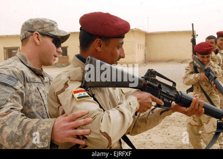 US Armee Sgt. Ryan Fox links mit Bravo Company, 3. Bataillon, 15. Infanterie-Regiment, 4. beraten und unterstützen Brigade der 3. US-Infanteriedivision, unterstützt irakische Armeesoldaten zugewiesen 8. irakische Armee Brigade, 1. Division, als die Soldaten Praxis Militäroperationen in urbanem Gelände Verfahren am Camp Taqaddum, Irak, am 8. März 2011.   Staff Sgt Tanya Thomas, US-Armee.  Veröffentlicht Stockfoto