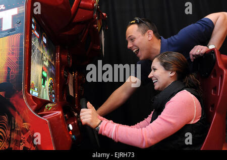 1st Lt. Erin Thomas, Temple, Texas, USA, spielt Arcade-Spiele, während ihr Ehemann, 2nd Lt. Will Thomas, die Aufregung im Lager als Sayliyah, Qatar, am 27. Januar genießt. Das militärische paar wurde eingesetzt, um verschiedenen Orten im Irak letztes Jahr, aber fand es einfach wieder durch die Teilnahme an den Rest des US Central Command und Rekuperation pass Programm an der Qatar-Basis. "Wer hätte gedacht, mitten in der Wüste eine kleine Oase!" sagte Chamberlin, während seines viertägigen Nachfrist mit seiner Frau. Offiziellen Armee Foto / Dustin Senger Stockfoto