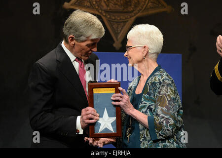 Sekretär der Armee John McHugh stellt die Medal Of Honor-Flagge für Nancy Weinstein, im Namen ihres Mannes, statt Sgt. Jack Weinstein, einer der 24 Armee-Veteranen geehrt während der Valor 24 Halle der Helden Induktion Zeremonie im Pentagon, Washington D.C., 19. März 2014.  Herr Leroy Council Stockfoto