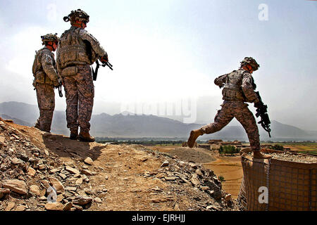 US Army Lieutenant Colonel Mark O'Donnell, Recht, springt auf eine Hesco Barriere wie er macht seinen Weg zu einer Feuerstellung mit Soldaten auf Fahrzeug Patrol Base Badel in Konar Provinz, Afghanistan, 14. August 2009 sprechen. O' Donnell, Kommandant des 1. Bataillons, 32. Infanterie-Regiment, war auf einer Routinemission, von Angesicht zu Angesicht junior Führer zu kommunizieren.   Staff Sgt Andrew Smith Stockfoto