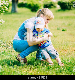 Glücklich Little Boy Child auf Sommergrün Rasen Wiese, Park, sonnigen Tag im Freien ausgeführt.  Kleinkind läuft auf er ist schön Mo Stockfoto