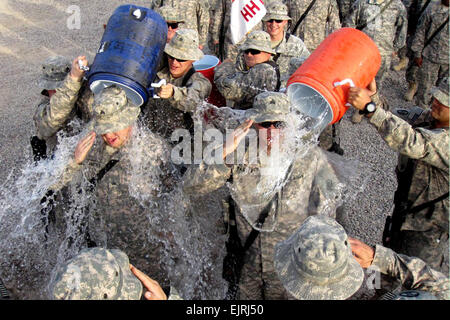 Aufsteiger US Armee SGT Timothy Simmons, links, und Sgt. Nathan Painter, Center, haben ihren früheren Reihen "gewaschen" von ihnen wie sie nach einer Förderung-Zeremonie in Bagdad, 25. Juli 2009 begrüssen. Die beiden wurden vom Spezialisten zum Feldwebel befördert. Sie sind der West Virginia Army National Guard 150. Armored Reconnaissance Squadron, 30. Heavy Brigade Combat Team zugewiesen.   SPC. Gregory Schlüssel Stockfoto