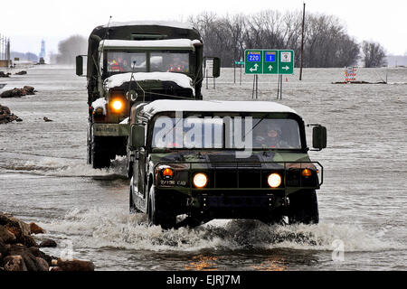 Minnesota Nationalgarde Soldaten aus dem Moorhead-basierte 2. kombinierte Arme Bataillon, fahren 136. Infanterie ein Humvee und eine fünf-Tonnen-LKW durch rauschende Wasser unten Minnesota Highway 1 in Oslo am 16. April 2011. Die Kleinstadt Minnesota am Red River Of The North ist von Wasser umgeben, so dass der Minnesota National Guard eine sichere Methode bietet des Kommens und Gehens in Oslo. Offizielle Air Force Tech Sgt. Erik Gudmundson Stockfoto