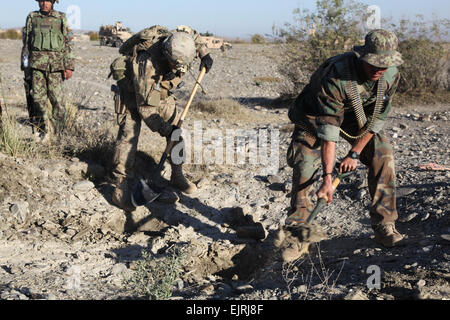 US Armee Sgt. Nathan West, links, aus Minneapolis, Mo., serviert mit C Truppe, 6. Squadron, 4. Kalvarienberg Regiment, 1st Infantry Division 3rd Brigade Combat Team, Task Force Duke und ein Afghan National Army Soldat, suchen eine mögliche Waffenlager, 29. November 2011, außerhalb Camp Parsa, Khowst Provinz, Afghanistan. Machen sich eine ständige Präsenz, Kräfte USA und die afghanische arbeiten, stellen sich die Einheimischen und Aufständischen Aktivität zu entmutigen. Stockfoto