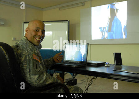 Armee Sgt. Elias Lantigua, Headquarters und Headquarters Company, Task Force 12, Camp Taji, Irak, lächelt als seine Tochter Micaela, betritt die Bühne während ihrer Abschlussfeier 7. Juni 2008, in Ansbach, Deutschland. Lantigua war einer der wenigen Soldaten im 12. Combat Aviation Brigade, die Gelegenheit gehabt, die Zeremonien per Video-streaming über das Internet zu sehen.  Sgt. 1. Klasse Chris Seaton, Task Force 12, Multinational Division-Bagdad Stockfoto