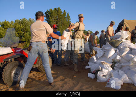 US Army Spc. Mathew Hollinrake, 1. Bataillon, 168. Infanterie-Regiment, Iowa Army National Guard, übergibt Sandsäcke ein Anwohner dazu beitragen ein Deich nördlich von Burlington, Iowa, 16. Juni 2008. Mitglieder der Nationalgarde Iowa unterstützen staatliche und lokale Agenturen bieten Sicherheit und helfen, Bereiche von großflächigen Überschwemmungen beschädigt erholen.  Master Sergeant Bill Wiseman Stockfoto