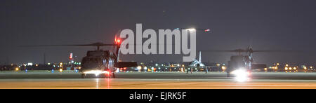 Black Hawk-Hubschrauber aus Texas Army National Guard warten mit ihren Motoren als die c-17 Globemaster III Flugzeug mit drei ehemaligen Geiseln Ansätze Lackland Air Force Base, Texas, 2. Juli 2008 ausgeführt. Drei US-Regierung Fremdfirmen wurden heute durch die kolumbianischen Sicherheitskräfte gerettet, nachdem da ihr Flugzeug abgestürzt ist in einer abgelegenen Gegend im Februar 2003 durch die Revolutionäre bewaffnete Kräfte von Kolumbien oder FARC, gefangen gehalten. Das Flugzeug ist in Travis Air Force Base, Kalifornien stationiert.  Lance Cheung Stockfoto