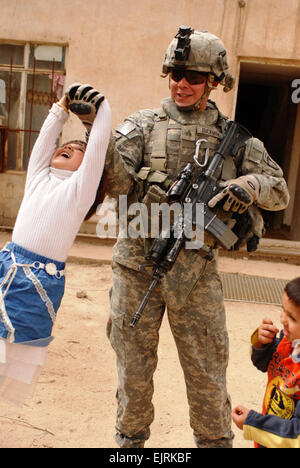 Sgt. Jason Ruckman Headquarters und Headquarters Company, 3. Brigade Combat Team, 101. US-Luftlandedivision, spielt mit irakischen Kindern während auf einer Mission in Mahmudiyah, etwa 35 Kilometer südwestlich von Bagdad, 18. März 2008.  Staff Sgt Tony Lindback siehe: www.defenselink.mil/news/newsarticle.aspx?id=50534 www.defenselink.mil/news/newsarticle.aspx?id=50534 Stockfoto