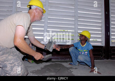 080721-A-5202T-115: PARAMARIBO, Surinam - Spc. Neal Eisenbraun von Wisner, Nebraska, Mitglied der 155. Ingenieur-Gesellschaft, South Dakota Army National Guard, übergibt einen Schaber, Reggield Misidjan, ein freiwilliger, dessen Mutter Lehrerin an der M.G.J. Poolschool ist. Reggield half die Soldaten, die Löcher in den Zement mit Putty am Montag, 21. Juli, in Paramaribo, Suriname zu füllen. Das Sanierungsprojekt ist Teil von Beyond the Horizon 2008.  Beyond the Horizon Übung trägt dazu bei, die Verbesserung der Lebensqualität für Suriname Menschen leben in ländlichen Gebieten und gleichzeitig die Verbesserung der Partner der Nation capabi Stockfoto