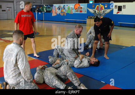 Staff Sgt Edward Durant ganz rechts, Headquarters und Headquarters Company, Combat Aviation Brigade CAB, hat das Ziel Schritt für Schritt während einer Combatives Klasse bei Wheeler Gym, Aug. 18. Sgt. 1. Klasse Robbie Turner stehend, ganz links, diente als ein weiterer Assistent Instructor zu helfen, die 25. CAB erste Abschlussklasse der Ebene eine zertifizierte Soldaten zu zertifizieren. : Staff SGT Tyrone C. Marshall Jr. | 25. combat Aviation Brigade Public Affairs Stockfoto