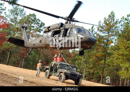 Zwei Fallschirmspringer aus der 407th Brigade Support Battalion, 2nd Brigade Combat Team, 82nd Airborne Division, legen einen Humvee vom Kabelbaum an der Unterseite des UH-60 Blackhawk Hubschrauber bei Schlinge Last training am 17. November.  Schlinge Last ist eine Technik verwendet, um Lieferungen schnell zu einem Gebiet zum anderen zu wechseln mit dem Hubschrauber.   Sgt. Susan willst, 2. BCT 82. Abn. Div. PAO Stockfoto