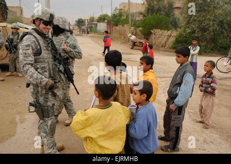 US Army 1st Lt. Mark Finley, 2. Bataillon, 8. Infanterie-Regiment, 2nd Brigade Combat Team, 4. US-Infanteriedivision, Gespräche mit irakischen Kinder während der Kordon und klopfe an Operationen in Afak, Irak, 30. November 2008.  Während der Operationen befragt die Soldaten irakische Bewohner über Lebensbedingungen.   Senior Airman Eric Harris Stockfoto