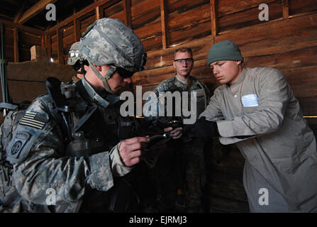 Pekin, Illinois native Spc. Kyle Canamore, ein Funker mit Unternehmen B, 2nd Battalion, 325. Airborne Infanterie-Regiment, 2nd Brigade Combat Team, 82nd Airborne Division links, zeichnet Informationen über einen lokalen Aufständischen Führer gegeben ihm durch "Dorf Häuptling" 1st Lt. Matthew Reid während einer situativen Übung in Fort Bragg Dez. 4.   /-News/2008/12/08/14909-realistisch-Training-Pr...  /-News/2008/12/08/14909-realistic-Training-prepares-Paratroopers-for-Combat/ Staff SGT Mike Pryor, 2. BCT 82. Abn. Div. öffentliche Angelegenheiten 081204-A-5406P-041 Stockfoto