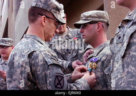 SPC. Christopher Halski steht hoch, als Oberstleutnant Gregory Baine ihn mit einer Army Commendation Medal während einer Preisverleihung, Dez. 10 präsentiert. Während seines Einsatzes verdient Halski zwei Purple Heart-Medaillen, zwei ARCOMs, eine irakische Kampagne Medaille und eine Bekämpfung der Infanterist-Abzeichen. Er ist ein Eingeborener von Omaha, Nebraska, und dient als Infanterist mit Unternehmen C, 2. Bataillon, 30. Infanterie-Regiment, 4th Brigade Combat Team, 10th Mountain Division, Multi-National Division-Bagdad. Baine, ein Eingeborener von Beaumont, Texas, ist der Bataillonskommandeur für 2. BN, 30. Inf. Regt..   Soldat zeichnet sich unter Kollegen in Stockfoto