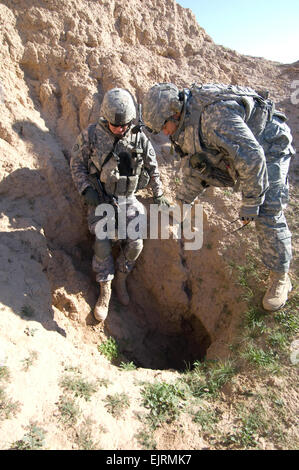 US Army Captain Scott Edelein und Staff Sgt Ian Martinez untersuchen ein Loch in der Nähe von einem vermuteten Waffenhandel Bereich. US-Armeesoldaten des 1. Bataillons, 24. Infanterie-Regiment, 1st Stryker Brigade Combat Team, 25. Infanterie-Division und irakische Armeesoldaten des 2. Bataillons, 19. Brigade, 5. Division Verhalten Fuß patrouillieren sucht des Udaim River Valley feindliche Waffenlager und Transportwege, Dez. 11. Diese gemeinsame Operation namens Hammer Verfolgung III soll der Handel mit Waffen in der Provinz Diyala, Irak zu stoppen. Stockfoto