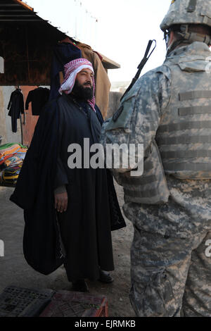 Ersten Lt. Kevin Chamberlain aus Detroit, Michigan, der Delta Company, 2. Bataillon, 27. Infanterie-Regiment, 3rd Brigade Combat Team, 25. Infanterie-Division, spricht mit einem lokalen irakischer Mann in Al Malha, Irak, über mögliche Verbesserungen im Bereich während einer Patrouille Präsenz, 12. Dezember 2008. Stockfoto