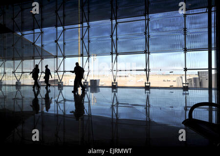 Passagiere, die Silhouette gegen ein großes Fenster, wie sie eine Abflug-Gate im Flughafen Barcelona, Spanien Fuß Stockfoto