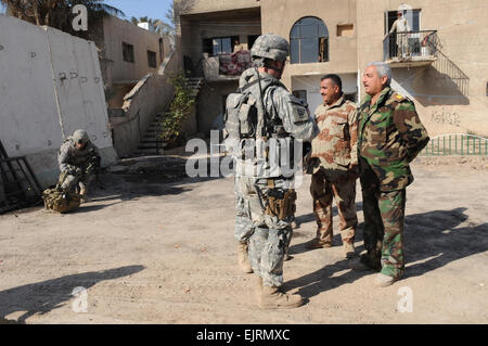 Irakische Armeeoffiziere grüßen US-Soldaten von B Truppe, 5. Kavallerie, 73. Regiment, 3rd Brigade Combat Team, 82nd Airborne Division, während die Verknüpfung vor Durchführung einer abgesessene Patrouille Muhallahs 710 und 712 in Muthana Zayuna, östlichen Bagdad, Irak, am 2. Januar 2009. Stockfoto