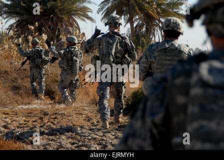 US Army Spc. Edgar Ruiz und Brian Huggins Pfc. 2. Platoon, Charlie Kompanie, 1. Bataillon, 2. Infanterie-Regiment 172. Infanteriebrigade signalisieren einander bei der am Straßenrand Abfertigung am Main Supply Route Tampa in der Nähe von Forward Operating Base Kalsu, Irak am 29. Dezember 2008. Stockfoto