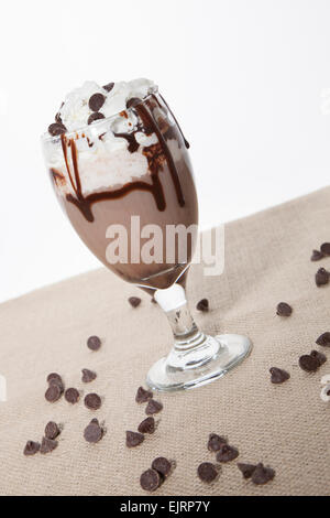 Ein Glas ist gefüllt mit einer Schokolade cocktail, garniert mit Schlagsahne, Schokolade Sirup und Schokolade-chips Stockfoto