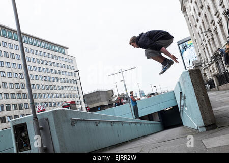 Freie Läufer Parkour zu üben. Parkour ist eine ganzheitliche Ausbildung Disziplin ermöglicht Practitionaers um von A nach B auf die wirksamste Weise möglich. Es entwickelte sich von militärische Ausbildung bei der Bekämpfung der Parcours und die Läufer konzentrieren sich auf die Pflege so viel Schwung wie möglich springen, schwingen, Rollen und Voltigieren mit ihrer städtischen Umgebung für den Antrieb. Waterloo, London. Stockfoto