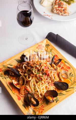 Eine bunte Platte hält Meeresfrüchte Fra Diavolo über Linguine. Stockfoto