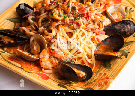 Eine bunte Platte hält Meeresfrüchte Fra Diavolo über Linguine. Stockfoto