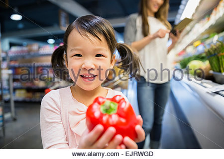 Porträt von lächelnden Mädchen halten rote Paprika