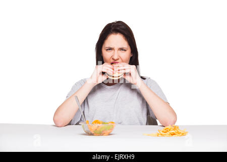 gesunde gegen Junk-Food-Konzept mit einer natürlichen Frau isoliert wogenden vor Obst essen und wählen Sie Pommes mit Hamburger, o Stockfoto