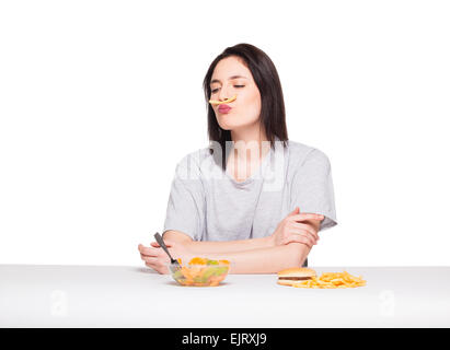 natürliche ausdrucksstarken Frau spielt mit Pommes frites, vor Junk-e- und gesund essen, isoliert auf weiss Stockfoto