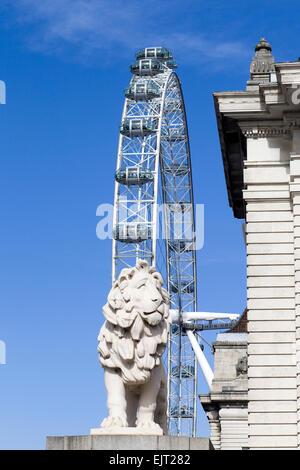 Die Coade steinernen Löwen bewacht das Südende der Westminster Bridge mit London Eye im Hintergrund England Stockfoto